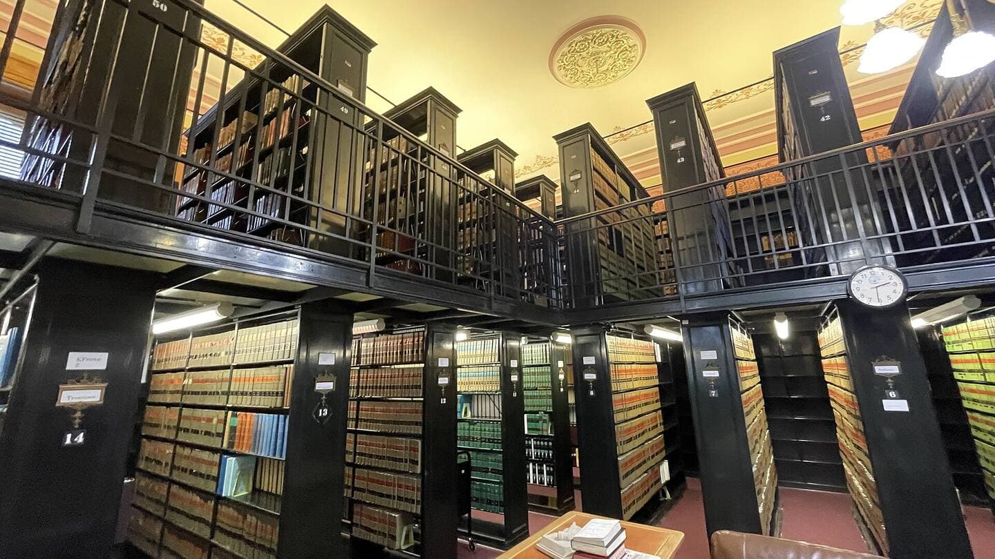 Two tiers of law library stacks filled with bound volumes of statutes and case reports