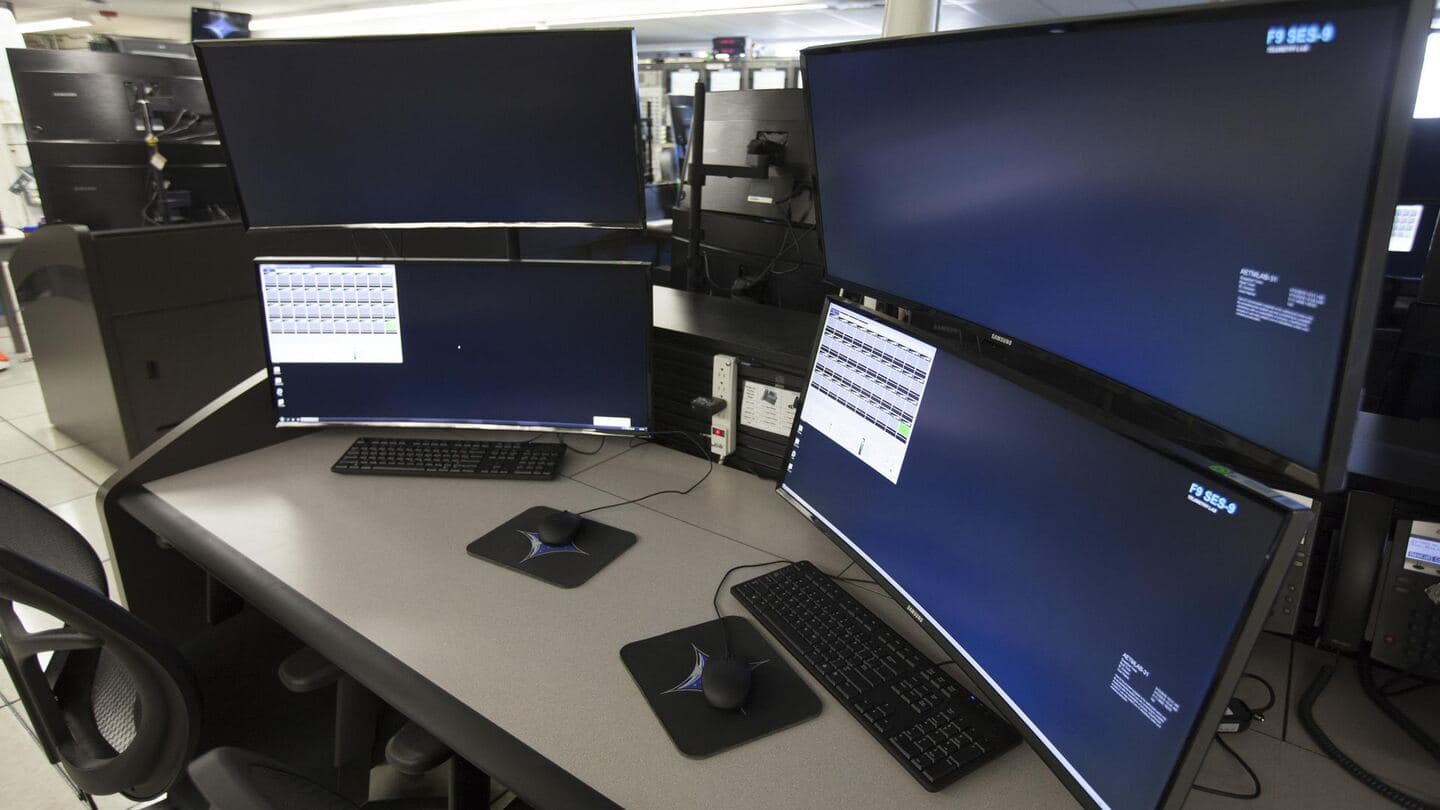 A desk with several computer monitors and a keyboard