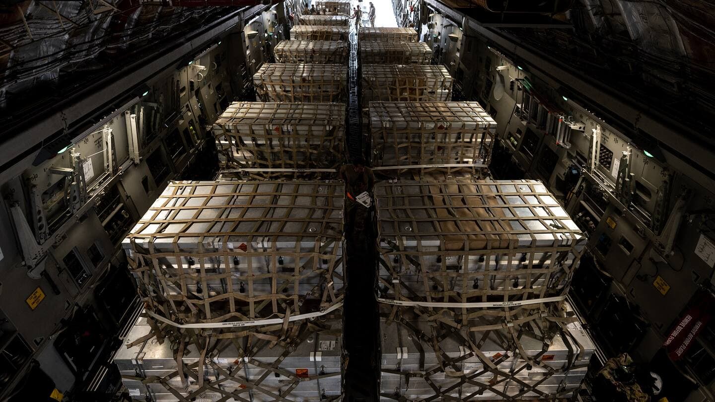 Netted cargo pallets loaded in two rows down the hold of a C-17 transport aircraft