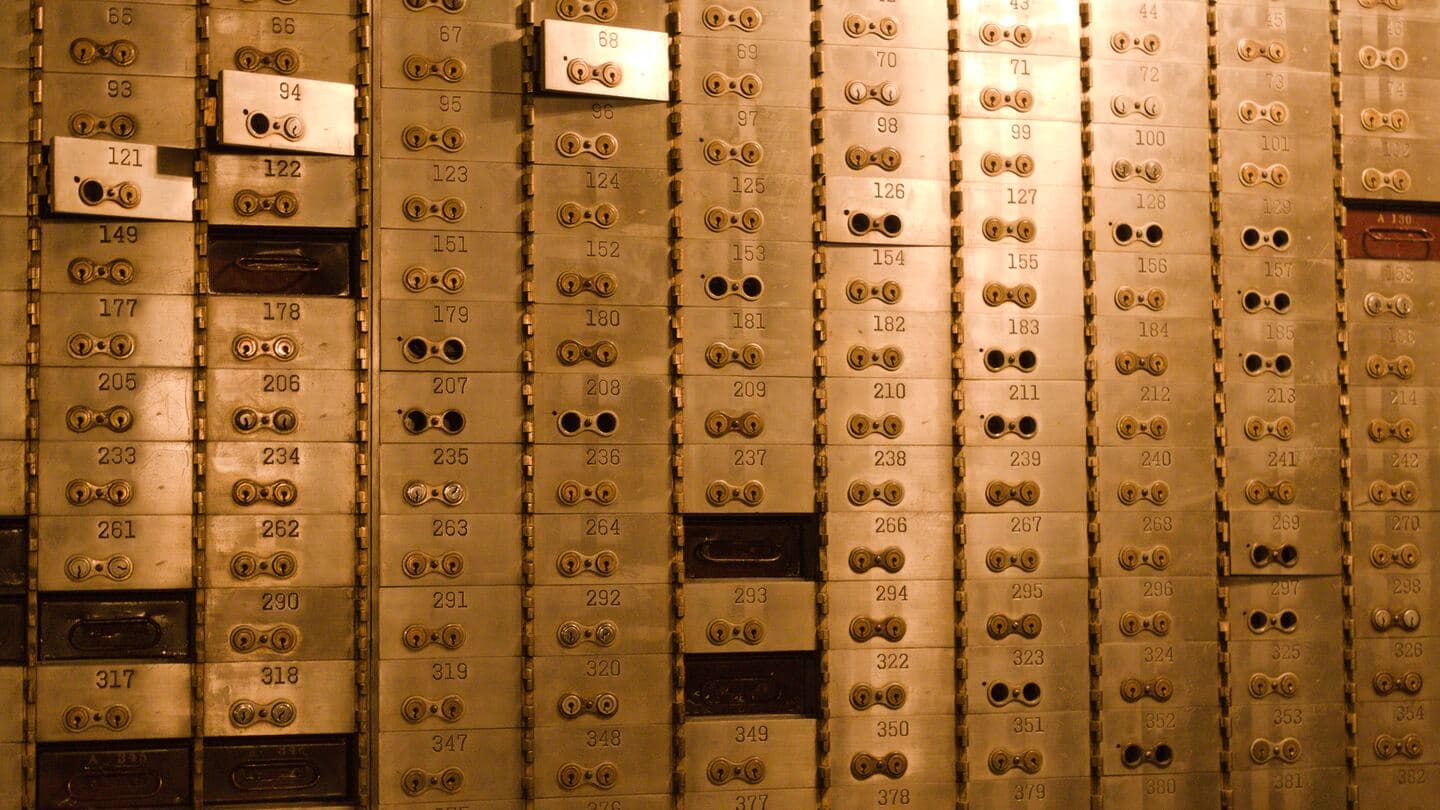 A wall of brass safe deposit boxes, each with its own numbered door and pair of locks