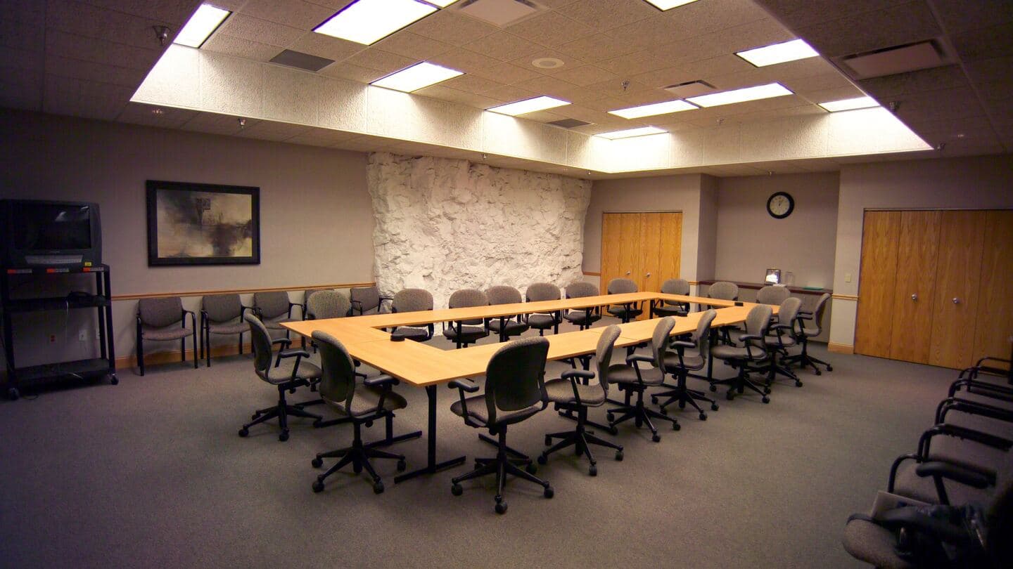 An empty conference room with tables set in a U and chairs ready for a planning session