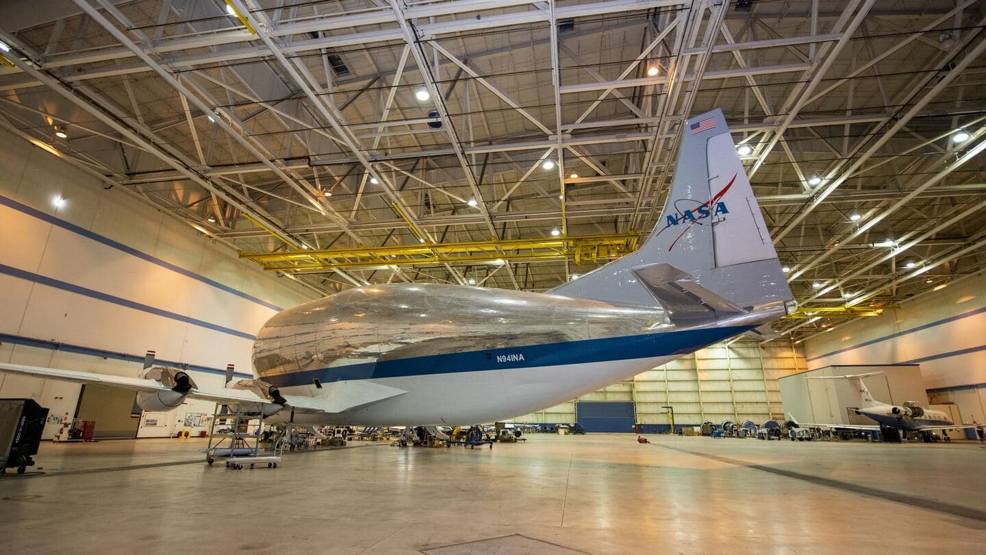A wide-body cargo aircraft parked inside a large hangar