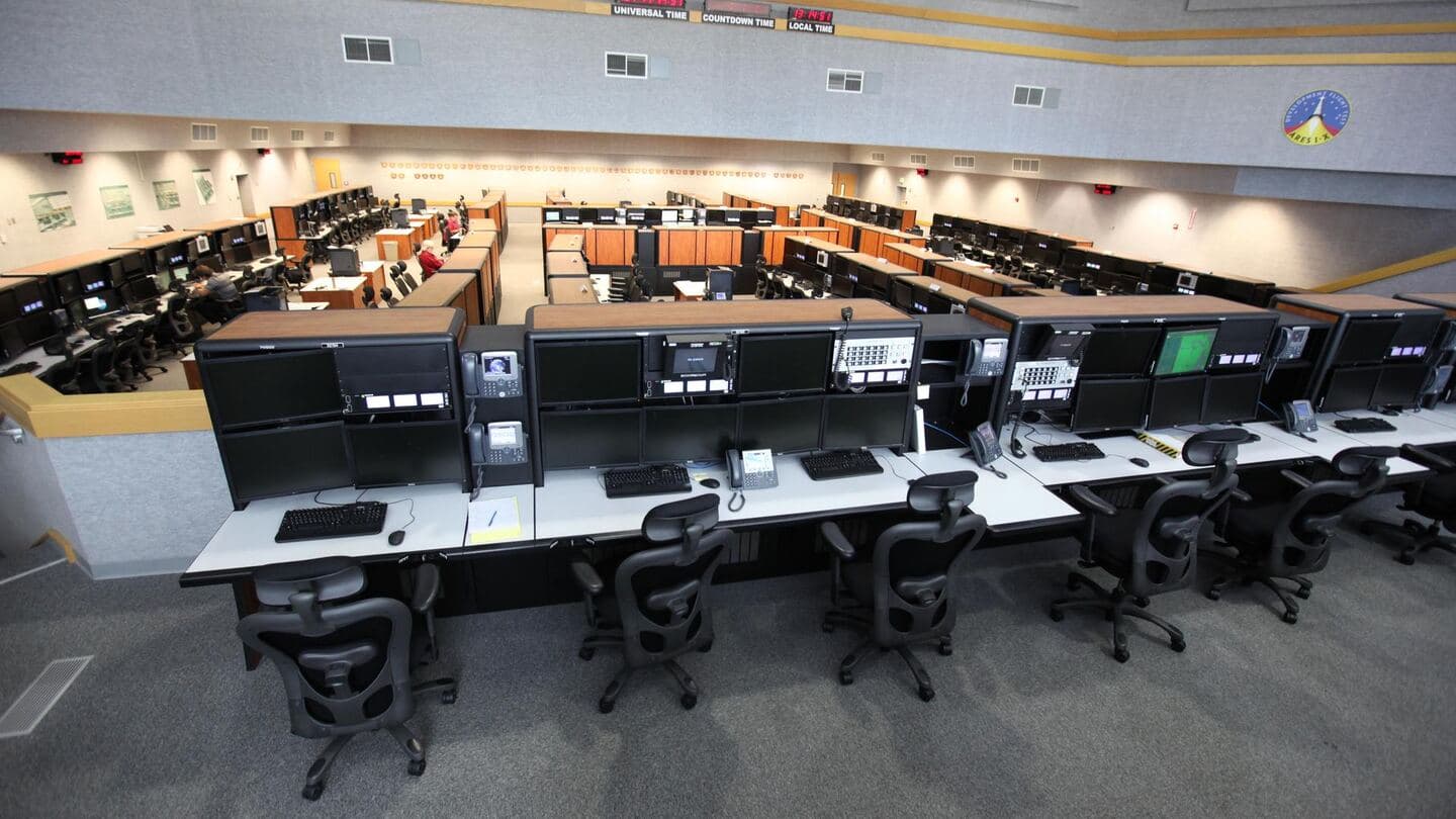 Rows of identical consoles in a large operations room