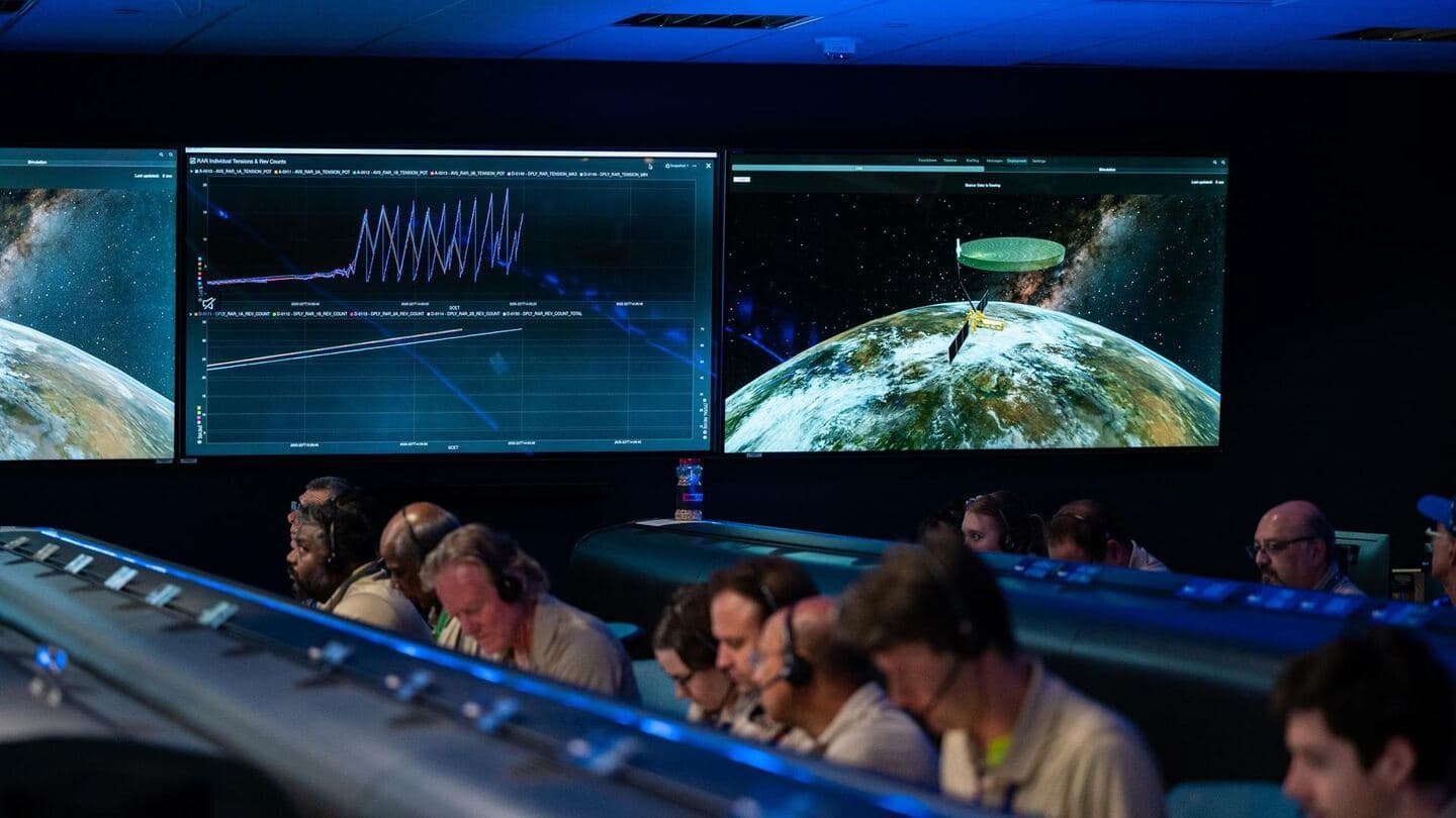 An operations room facing a wall of large display screens