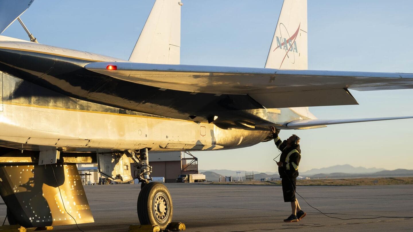 A crew chief inspecting the tail section of a jet on the ramp
