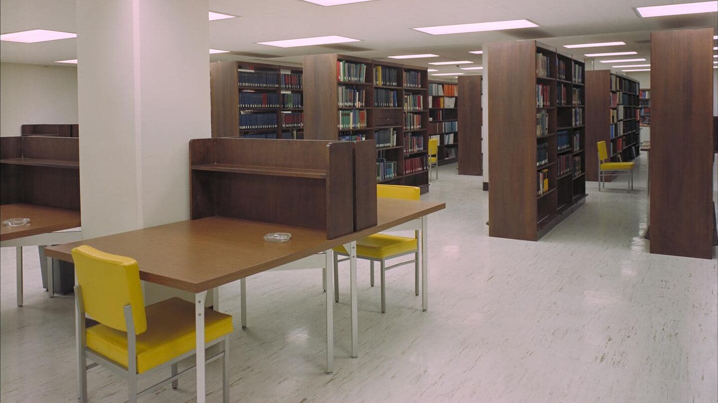 A technical library with bookshelves, study carrels, and a table