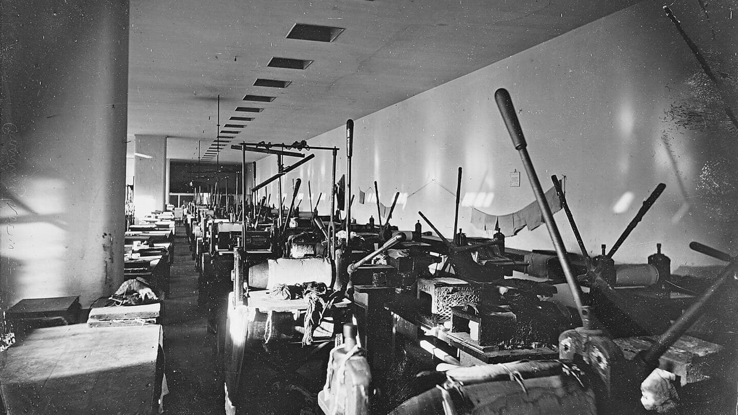 A long pressroom lined with rows of hand-operated printing presses, nineteenth century