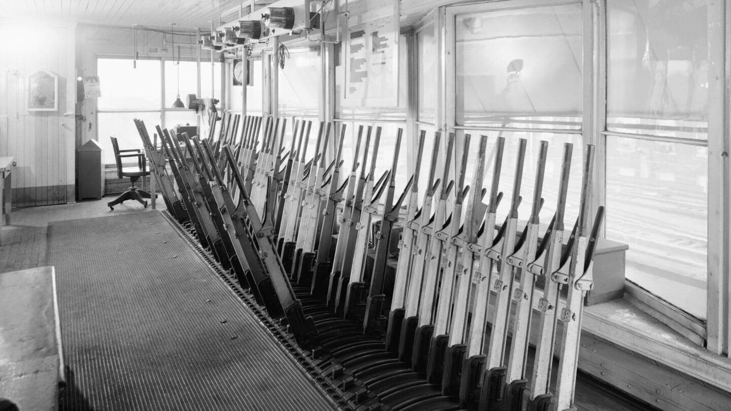 A long row of mechanical interlocking levers in a railroad signal tower switch room