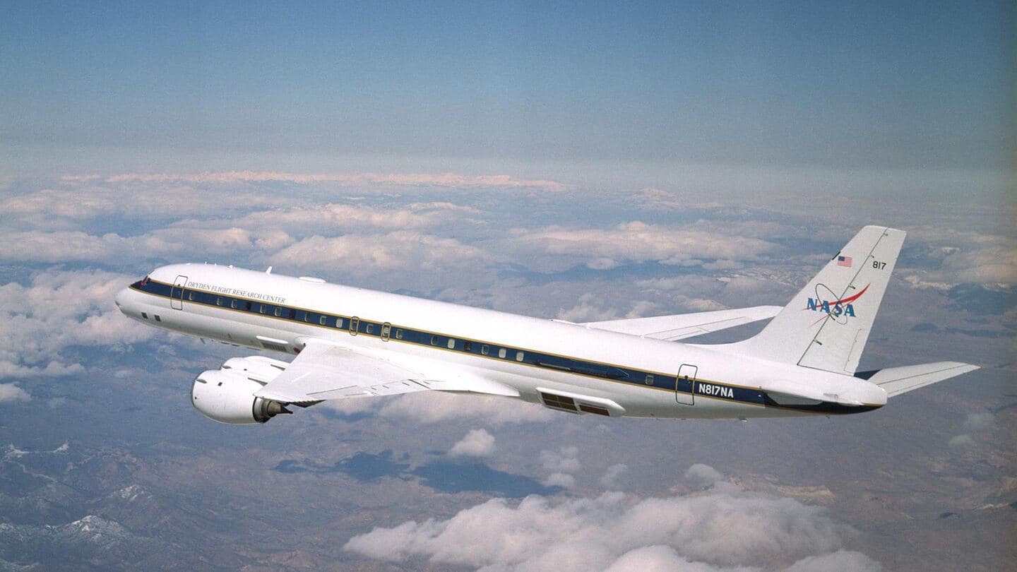 A four-engine research jet in flight above the clouds
