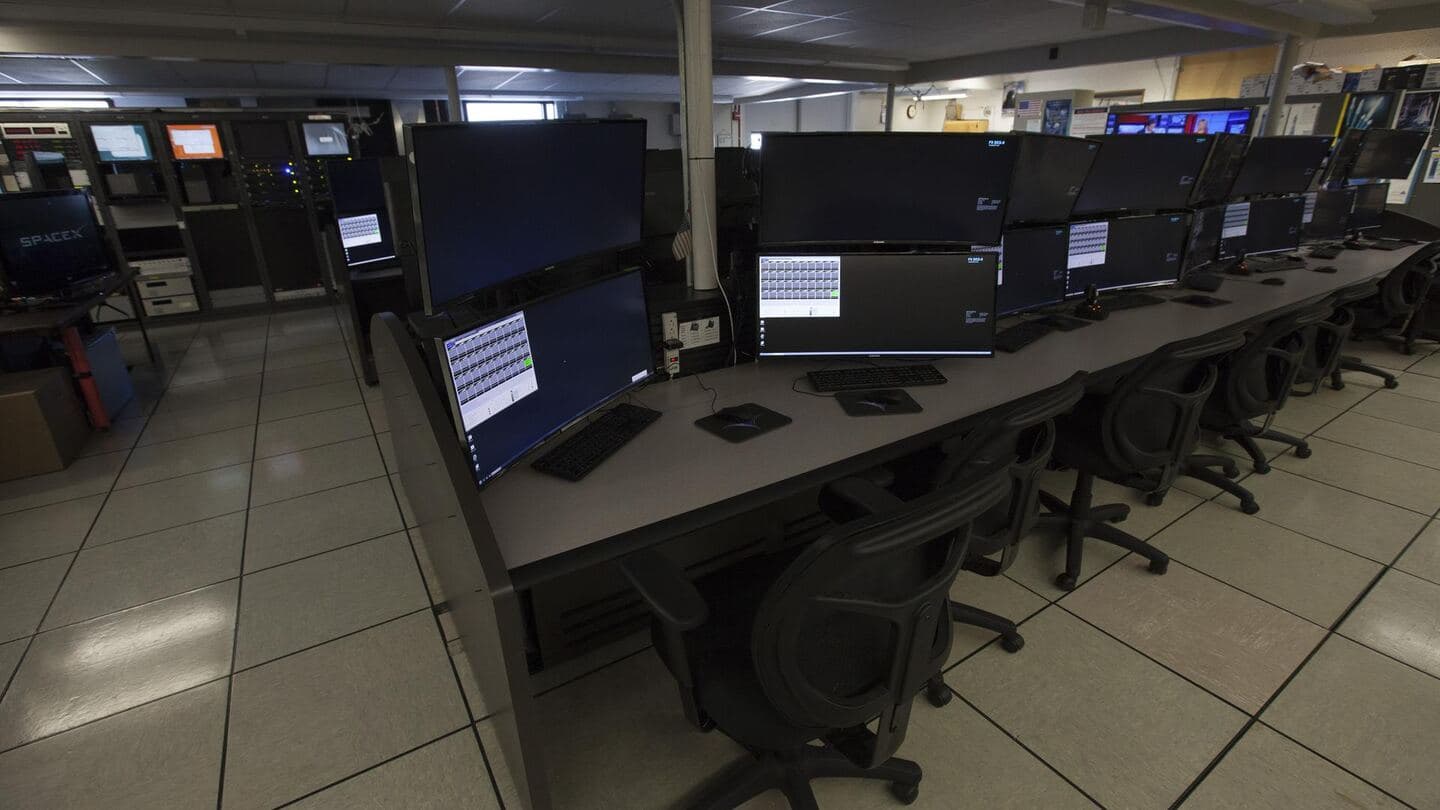An empty computer lab with rows of workstations