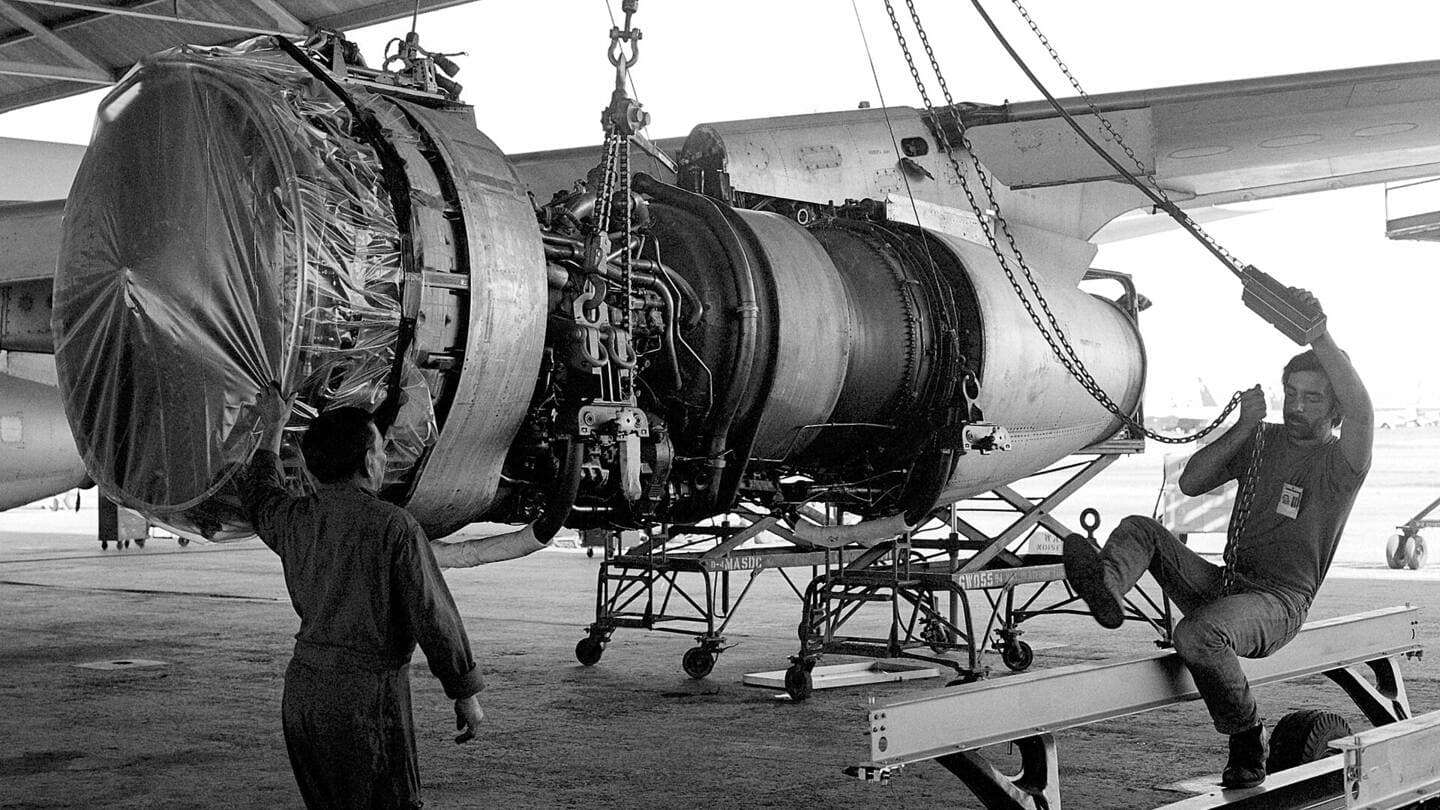 Black-and-white photo of a jet engine on a maintenance stand